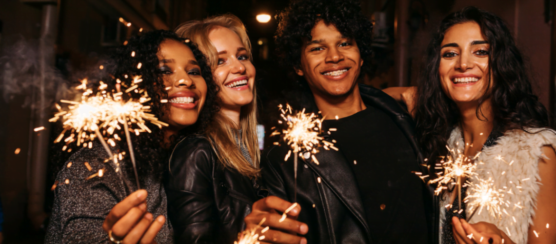 diverse team of employees holding sparklers at a company party