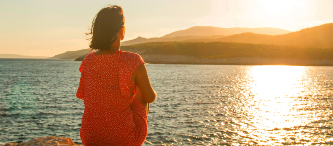 woman sitting by water and thinking