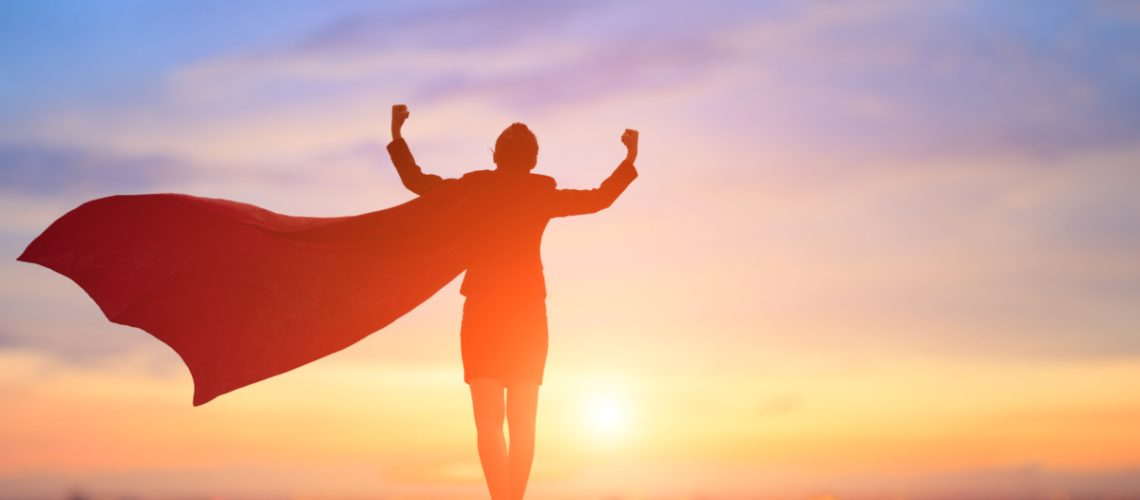 silhouette of woman dressed like super hero raising hands in the air